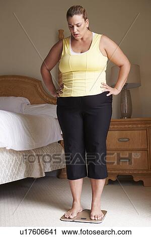 Overweight Woman Weighing Herself On Scales In Bedroom View Large Photo Image Stock Image - Overweight Woman Weighing Herself On Scales In Bedroom. Fotosearch