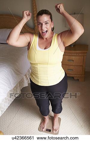 Overweight Woman Weighing Herself On Scales In Bedroom View Large Photo Image Stock Image - Overweight Woman Weighing Herself On Scales In Bedroom. Fotosearch