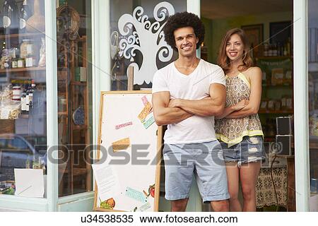 Stock Photography - Owners Of Delicatessen Standing Outside Shop Together. Fotosearch
