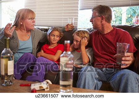 Stock Photo - Parents Arguing On Sofa With Children Smoking And Drinking. Fotosearch
