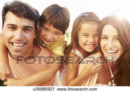 Stock Photo - Parents Giving Children Piggyback Ride In Garden . Fotosearch
