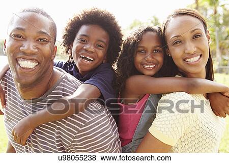 Parents Giving Children Piggyback Ride In Garden View Large Photo Image Stock Photo - Parents Giving Children Piggyback Ride In Garden . Fotosearch