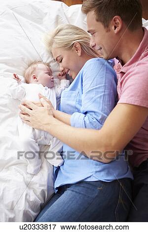Parents Lying With Baby Girl In Bed Together View Large Photo Image Stock Photo - Parents Lying With Baby Girl In Bed Together. Fotosearch
