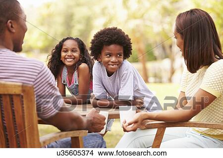 Parents Relaxing Whilst Children Play In Garden View Large Photo Image Picture - Parents Relaxing Whilst Children Play In Garden . Fotosearch
