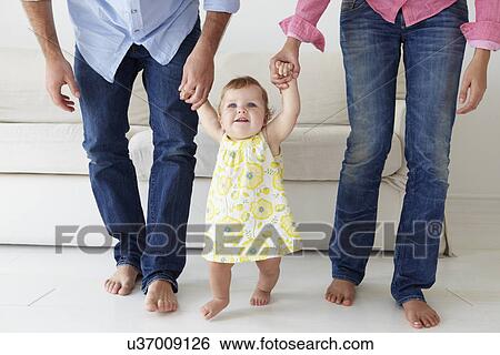 Parents teaching baby girl to walk View Large Photo Image Stock Photograph - Parents teaching baby girl to walk. Fotosearch