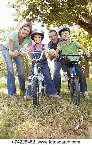 Stock Image - Parents with young children on bikes. Fotosearch
