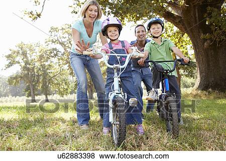 Parents with young children on bikes View Large Photo Image Stock Photo - Parents with young children on bikes. Fotosearch