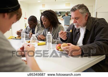 People Sitting At Table Eating Food In Homeless Shelter View Large Photo Image Stock Photo - People Sitting At Table Eating Food In Homeless Shelter. Fotosearch