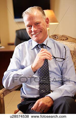 Stock Photo - Portrait Of Businessman Sitting In Chair. Fotosearch