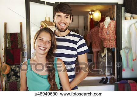 Stock Image - Portrait Of Couple Running Clothing Shop Together. Fotosearch