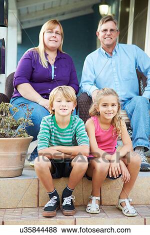 Portrait Of Family Sitting Outside House View Large Photo Image Stock Photo - Portrait Of Family Sitting Outside House. Fotosearch