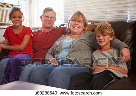 Portrait Of Happy Family Sitting On Sofa Together View Large Photo Image Stock Photo - Portrait Of Happy Family Sitting On Sofa Together. Fotosearch