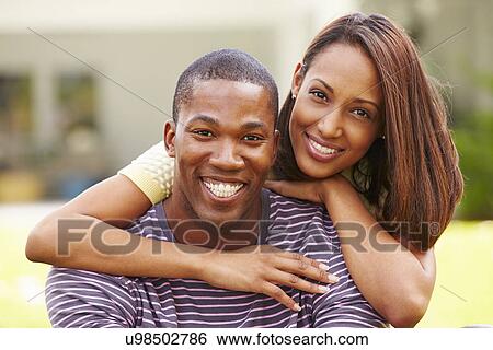 Stock Photograph - Portrait Of Happy Young Couple In Garden. Fotosearch