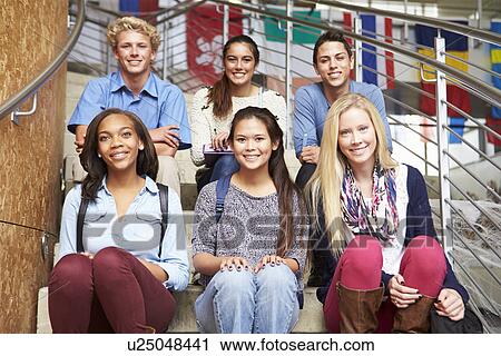 Stock Image - Portrait Of High School Students Sitting Outside Building. Fotosearch