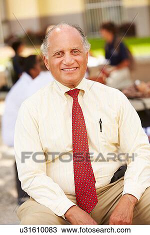 Portrait Of High School Teacher Sitting On School Campus View Large Photo Image Stock Image - Portrait Of High School Teacher Sitting On School Campus. Fotosearch