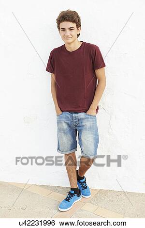 Stock Photograph - Portrait Of Hispanic Teenage Boy Leaning Against Wall. Fotosearch