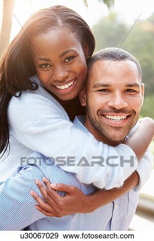 Stock Photo - Portrait Of Loving African American Couple In Countryside. Fotosearch