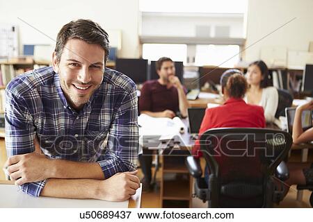 Stock Photo - Portrait Of Male Architect With Meeting In Background. Fotosearch