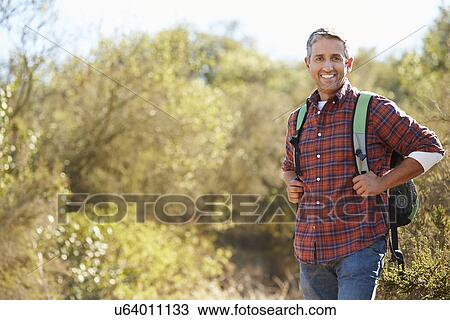 Portrait Of Man Hiking In Countryside Wearing Backpack View Large Photo Image Stock Image - Portrait Of Man Hiking In Countryside Wearing Backpack. Fotosearch