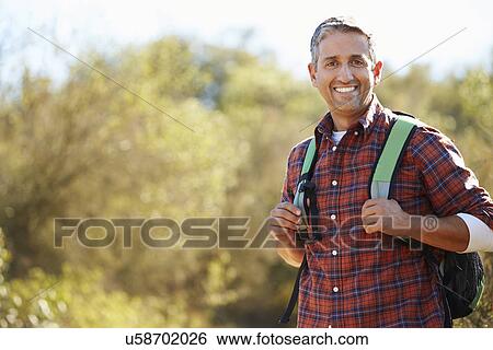 Portrait Of Man Hiking In Countryside Wearing Backpack View Large Photo Image Stock Photograph - Portrait Of Man Hiking In Countryside Wearing Backpack. Fotosearch
