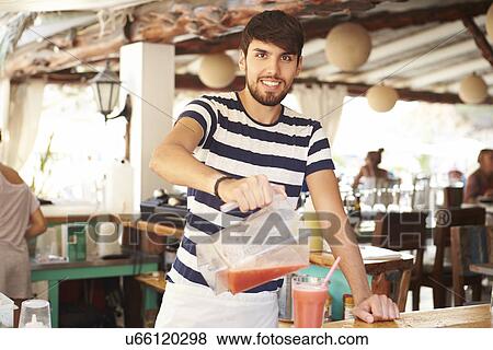 Stock Photo - Portrait Of Man In Restaurant Making Fruit Smoothies. Fotosearch