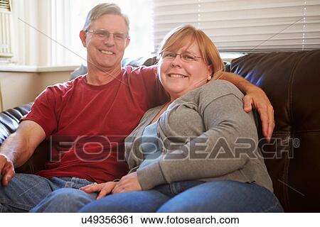 Portrait Of Mature Couple Sitting On Sofa At Home View Large Photo Image Stock Image - Portrait Of Mature Couple Sitting On Sofa At Home. Fotosearch