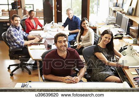 Stock Image - Portrait Of Office Staff At Table In Architect's Office. Fotosearch