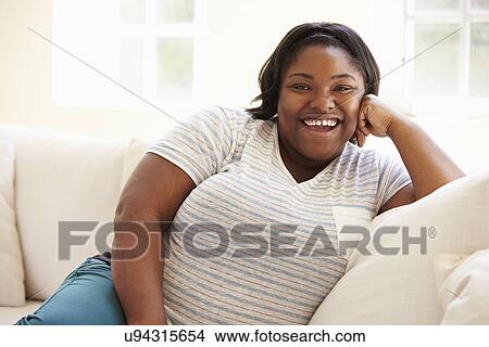 Picture - Portrait Of Overweight Woman Sitting On Sofa. Fotosearch