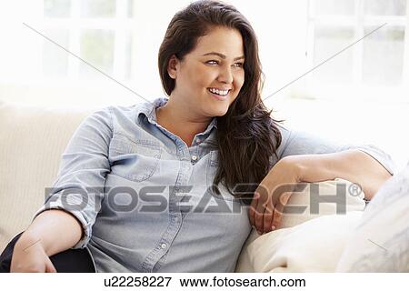 Stock Photo - Portrait Of Overweight Woman Sitting On Sofa. Fotosearch