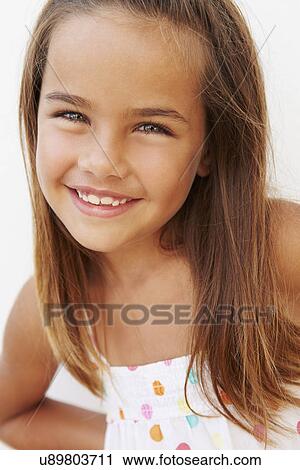 Stock Image - Portrait Of Pretty Hispanic Girl Standing By Wall. Fotosearch