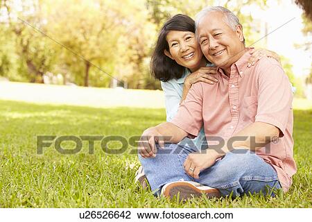 Stock Image - Portrait Of Senior Asian Couple Sitting In Park Together. Fotosearch