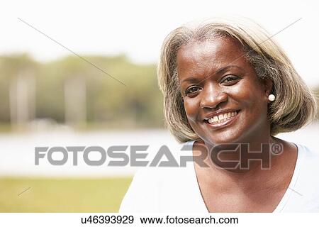 Stock Photo - Portrait Of Senior Woman Sitting In Garden. Fotosearch
