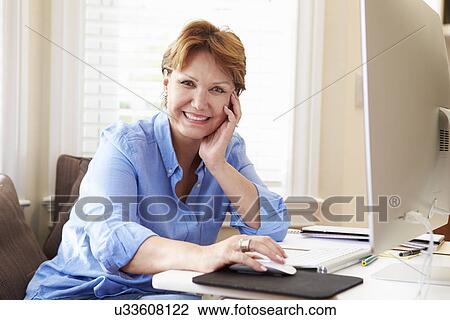 Stock Image - Portrait Of Senior Woman Using Computer At Home. Fotosearch