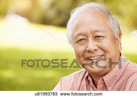 Portrait Of Smiling Senior Asian Man Sitting In Park View Large Photo Image Stock Image - Portrait Of Smiling Senior Asian Man Sitting In Park . Fotosearch