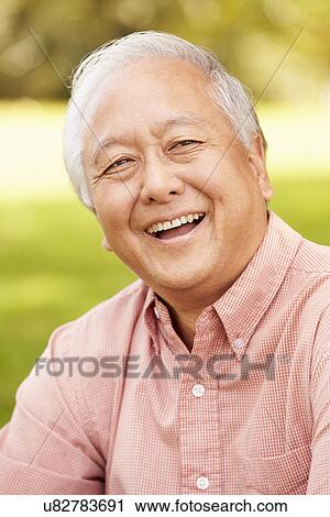 Portrait Of Smiling Senior Asian Man Sitting In Park View Large Photo Image Stock Image - Portrait Of Smiling Senior Asian Man Sitting In Park . Fotosearch