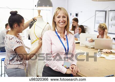 Stock Photograph - Portrait Of Teacher Helping College Fashion Students. Fotosearch
