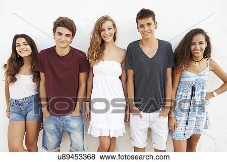 Stock Photo - Portrait Of Teenage Group Leaning Against Wall. Fotosearch
