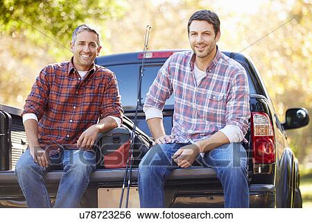 Stock Photograph - Portrait Of Two Men In Pick Up Truck On Camping Holiday. Fotosearch