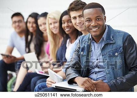 Stock Image - Portrait Of University Students Outdoors On Campus. Fotosearch