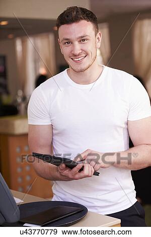Portrait Of Waiter In Hotel Using Digital Tablet View Large Photo Image Stock Photo - Portrait Of Waiter In Hotel Using Digital Tablet. Fotosearch