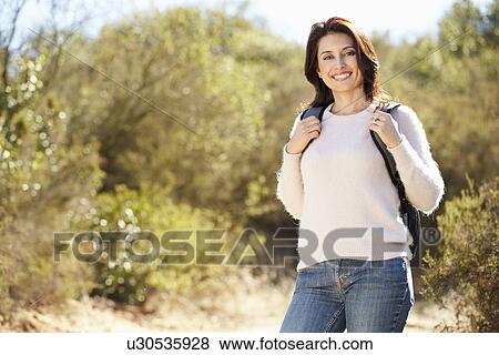 Portrait Of Woman Hiking In Countryside Wearing Backpack View Large Photo Image Stock Photo - Portrait Of Woman Hiking In Countryside Wearing Backpack. Fotosearch