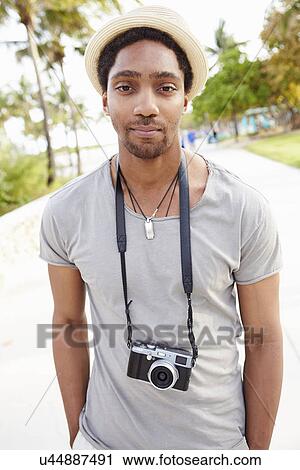 Stock Image - Portrait Of Young Man Carrying Camera. Fotosearch