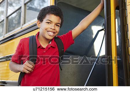 Stock Photograph - Pre teen boy getting on school bus. Fotosearch