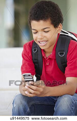 Pre teen boy with phone at school View Large Photo Image Stock Photography - Pre teen boy with phone at school. Fotosearch