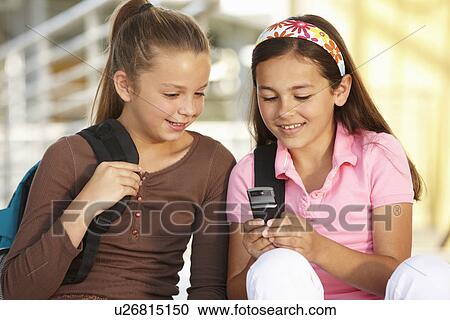 Pre teen girls in school with cellphone View Large Photo Image Stock Image - Pre teen girls in school with cellphone. Fotosearch