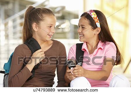 Pre teen girls in school with cellphone View Large Photo Image Stock Photo - Pre teen girls in school with cellphone. Fotosearch