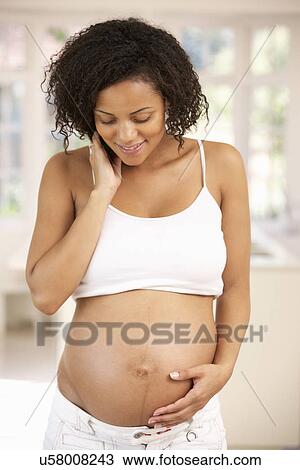 Stock Image - Pregnant woman at home. Fotosearch
