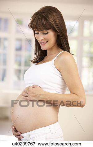 Pregnant woman at home View Large Photo Image Stock Photo - Pregnant woman at home. Fotosearch