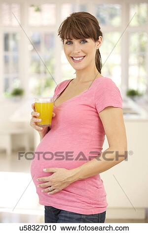 Stock Image - Pregnant woman drinking fruit juice. Fotosearch