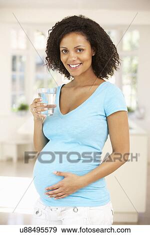 Stock Photo - Pregnant woman drinking water. Fotosearch